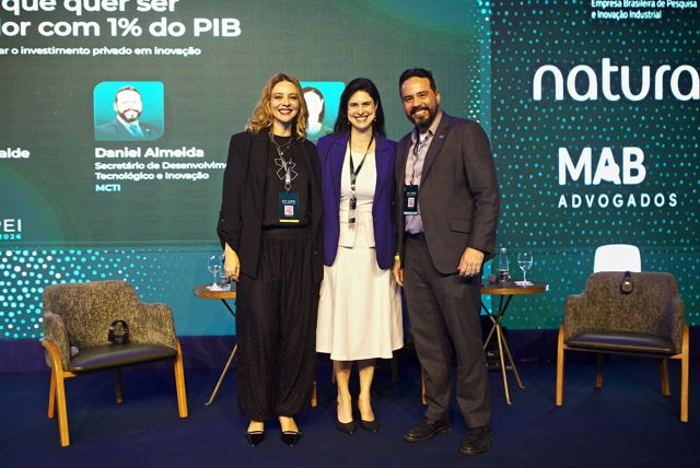 Convidados de um painel posam no palco